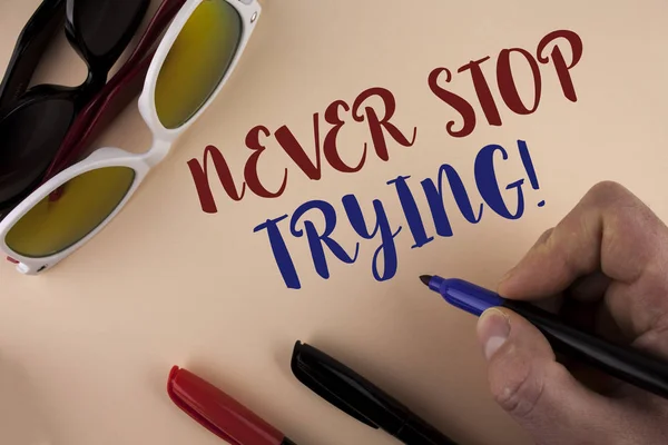 Text sign showing Never Stop Trying Motivational Call. Conceptual photo go on do not give up Self confidence written by Man on plain background holding Marker Sun Glasses and Markers next to it