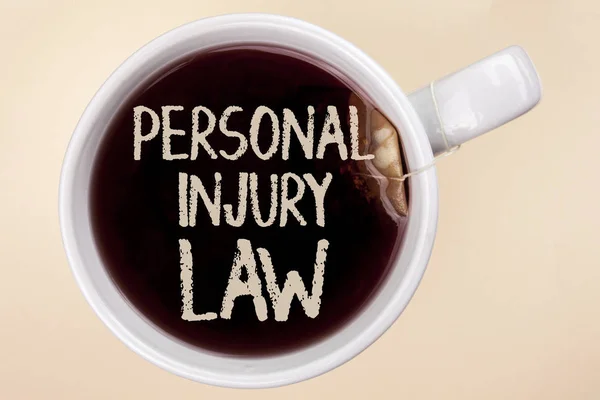 A kézírás szöveg írása személyi sérülésekről szóló törvény. Koncepció, azaz garantálja a jog esetén a veszélyek és kockázatok írt a sima háttérben Tea Bag egy csésze Tea. — Stock Fotó