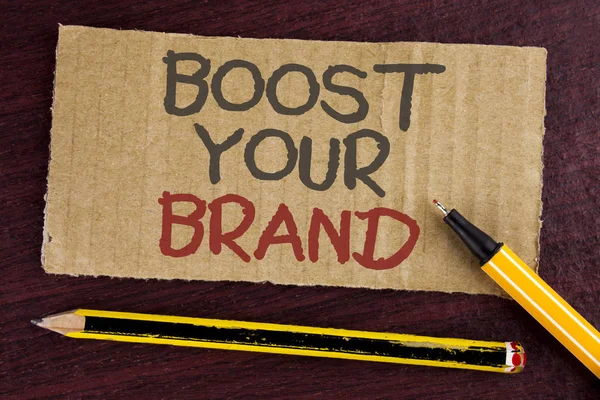 Signe texte montrant Boost Your Brand. Photo conceptuelle améliorer le nom de vos modèles dans votre domaine surmonter les concurrents écrits sur carton pièce sur fond en bois conduit stylo et crayon à côté de celui-ci . — Photo