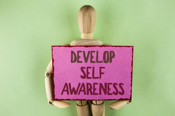 Почерк написания текста развивать самопознание. Концепция, означающая улучшение вашей информации об окружающих событиях, написанной на липкой бумаге, которую держит Wooden Jointed Toy на обычном фоне
