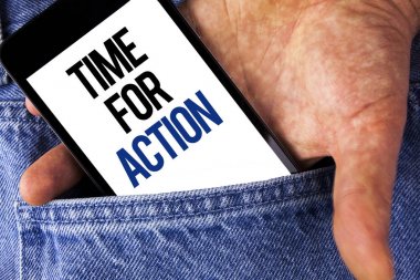 Zaman için eylem gösteren not yazma. İş fotoğraf vitrine bir şeyler yap şimdi Yasası tarafından adam kot arka planda tutarak cep telefonu ekran üzerinde yazılı şu anda belirli bir amaca.