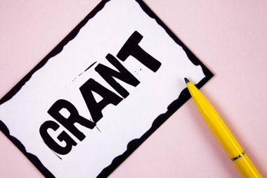 El yazısı metin Grant. Bir amaç düz pembe arka plan kalem yanında beyaz yapışkan not kağıdına yazılı burs için bir organizasyon veya hükümet tarafından verilen para anlam kavramı.