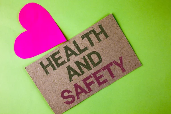 Conceptual hand writing showing Health And Safety. Business photo text being in good condition harmless Workouts Healthy food written on Cardboard Piece on the plain background Heart next to it — Stock Photo, Image