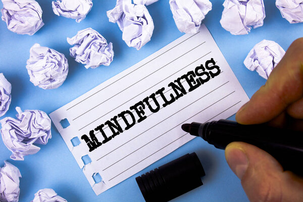 Word writing text Mindfulness. Business concept for Being Conscious Awareness Calm Accept thoughts and feelings written by Man on Notepad paper on plain blue background Paper Balls next to it.