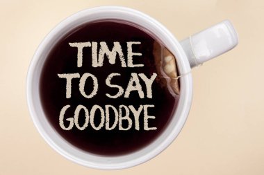 Zaman için Say Goodbye yazma el yazısı metin. Ayrılık anı bırakarak ayrılık elveda dilek çay bir fincan çay poşeti düz arka plan üzerinde yazılı biten anlam kavramı.