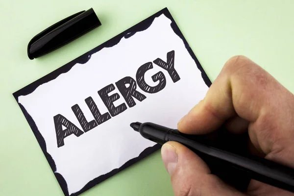 Handwriting text Allergy. Concept meaning damages in immunity due to hypersensitivity get it diagnised written by Man on White sticky note paper holding Marker on plain background.
