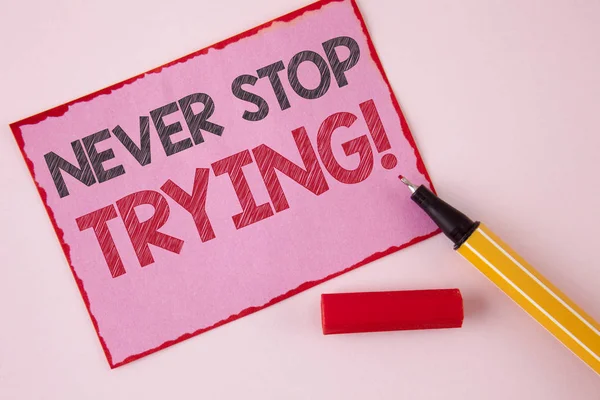 Signo de texto que muestra Never Stop Trying Motivational Call. Foto conceptual seguir adelante no renunciar a la confianza en sí mismo escrito en papel de Pink Sticky Note en el fondo llano pluma al lado de ella . — Foto de Stock