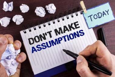 Gösterilen metin işaret varsayımlar yapmak yapmak. Kavramsal fotoğraf ipucu alternatif Marker ahşap arka plan buruşuk kağıt topları üzerinde tutarak not defteri adam tarafından yazıldı gerçekler olmadan olaylar gelecek tahmin