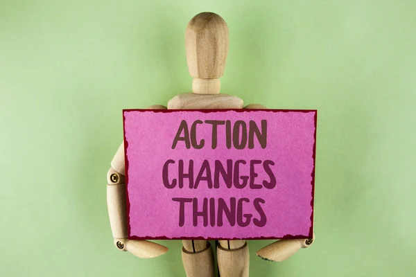 Handwriting text writing Action Changes Things. Concept meaning doing something is like chain Improve Reflects written on Sticky note paper holding by Wooden Robot Toy on plain background. — Stock Photo, Image