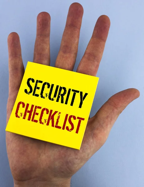 Escribir una nota que muestra la lista de verificación de seguridad. Lista de presentación de fotos de negocios con nombres autorizados para ingresar los procedimientos de autorización escritos en Sticky Note Paper sobre el fondo azul plano Hand . — Foto de Stock