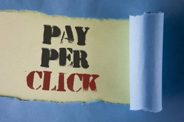 Pay Per Click gösterilen not yazma. Reklamlar Reklam Seo pazarlama gözyaşı katlanan kağıt altında düz beyaz arka plan üzerinde yazılı ziyaretçilerden para almak showcasing iş fotoğraf.