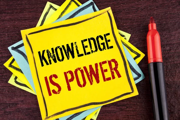 Texte manuscrit La connaissance est le pouvoir. Concept signifiant que l'apprentissage vous donnera l'avantage sur les autres écrits sur papier de note collant jaune sur fond en bois Marqueur à côté . — Photo