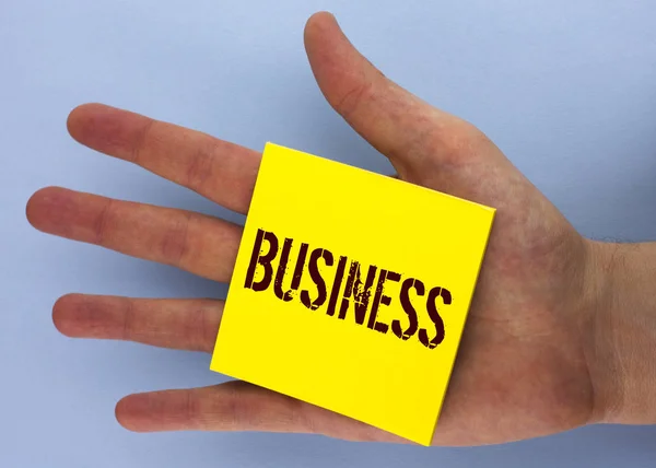 Text sign showing Business. Conceptual photo Marketing and sales stagedy for new projects written on Yellow Sticky Note Paper placed on Hand on the plain background. — Stock Photo, Image