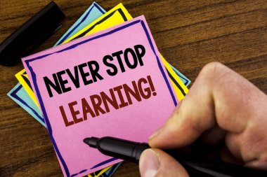 Word metin durdurmak öğrenme motivasyon arama asla yazma. İş kavramı için pembe yapışkan not kağıdı marker ahşap arka plan üzerinde tutan adam tarafından yazılı becerilerini geliştirmek kendinizi eğitmek tutmak 