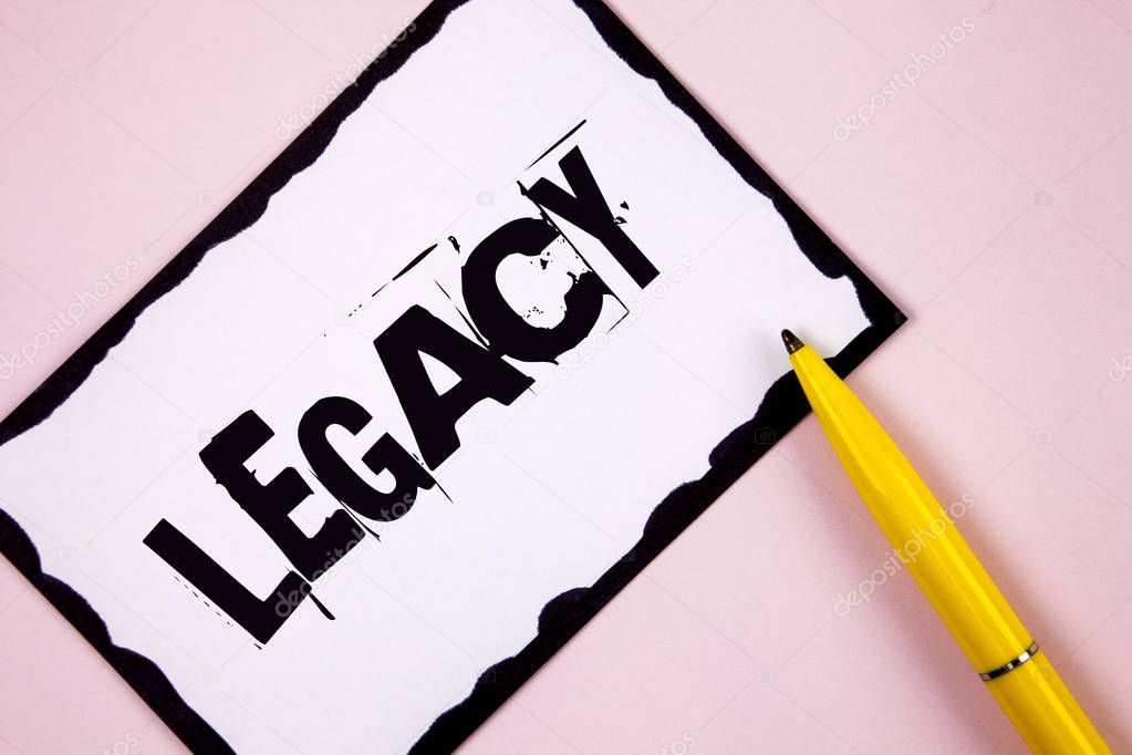 Handwriting text Legacy. Concept meaning Transmitted Received from an ancestor Money Properties given by will written on White Sticky note paper on plain Pink background Pen next to it.