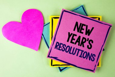 Yeni yıl kararları gösterilen not yazma. Sonraki 365 gün düz arka plan kalp yanında pembe yapışkan not kağıdına yazılı gol amaçları hedefleri kararlar vitrine iş fotoğraf.