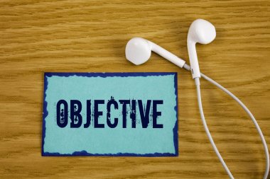 Amaç gösterilen not yazma. İstenilen hedef şirket misyonu ahşap arka plan Handsfree yanında üzerinde yapışkan not kağıdına yazılı olması planlanan hedef vitrine iş fotoğraf elde.