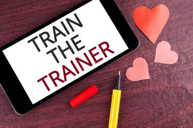 Tren eğitmen gösterilen not yazma. Öğrenme tekniği öğretmenler kendileri ahşap arka plan kalem ekranda hareket eden telefon ve kalpleri üzerinde yazılı olan öğrenciler vitrine iş fotoğraf