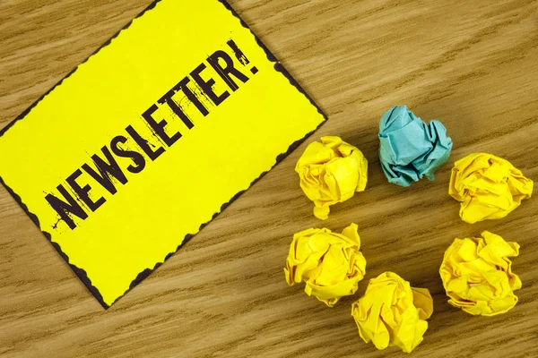 Handgeschreven tekst nieuwsbrief motiverende noemen. Begrip betekenis Bulletin periodiek verzonden naar leden van groep geschreven op notitie papier op houten achtergrond verfrommeld papier ballen ernaast. — Stockfoto