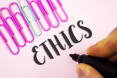 Metin etik yazılı kelime. İş kavramı sağlanmasında eşitlik dengesi diğerlerinin yanı sıra düz pembe arka plan kağıt Pins yanındaki işaret tutan adam tarafından yazılmış ahlaki prensipleri.