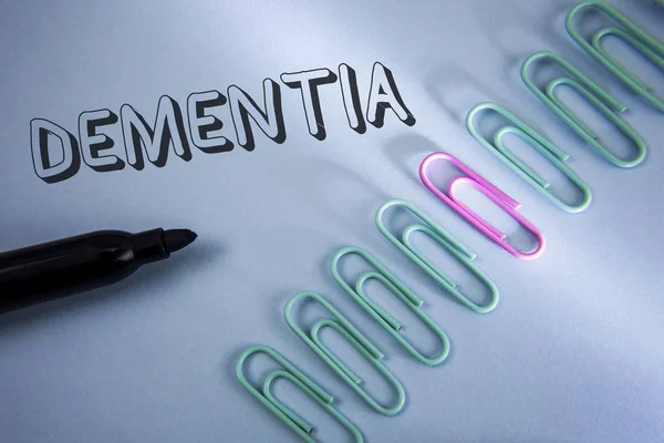 Handwriting text Dementia. Concept meaning Long term memory loss sign and symptoms made me retire sooner written on Plain Blue background Paper Clips and Marker next to it. — Stock Photo, Image