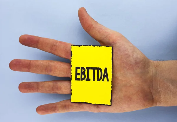 Концептуальні рукописний показ Ebitda. Бізнесі фото демонстрації заробіток, перш ніж податкових вимірюється для оцінки продуктивності компанії написано жовтого паперу Клейка примітка просте тло руку. — стокове фото