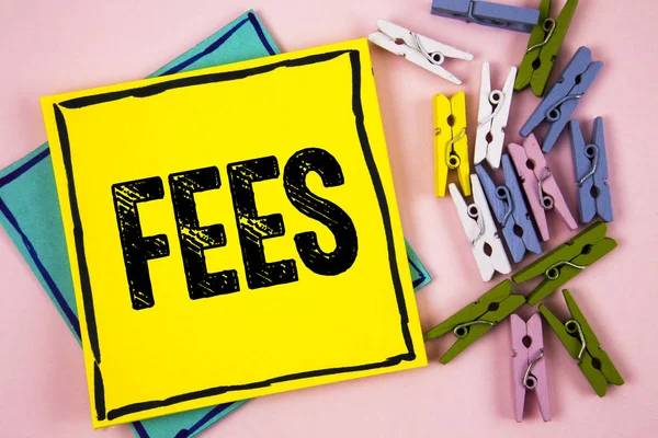 Text sign showing Fees. Conceptual photo Online creative agency charges product components hourly costs written on Sticky Note Paper on plain background Paper Balls and Wooden Clips.