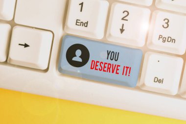 Word yazma metni You Deserve It. İş kavramı için nitelikleri veya eylemleri beyaz arka plan tuş kopyalama alanı üzerinde boş not kağıdı ile Beyaz pc klavye nedeniyle olmalıdır.