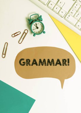 Gramer yazısını gösteren bir işaret. Kavramsal fotoğraf tüm sistem yapı dili söz dizimi ve morfoloji Masanın üzerinde saat ve kağıt ataçları ile kopya alanı ile yatıyordu.