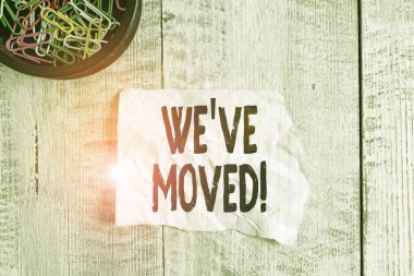 Taşındığımızı gösteren kavramsal el yazısı. Üzüntü ve sempati dolu bir iş fotoğrafı sergisi, ahşap arka plana yerleştirilmiş kağıt ve karton kırışıklıkları anlatıyor ya da yapıyor..