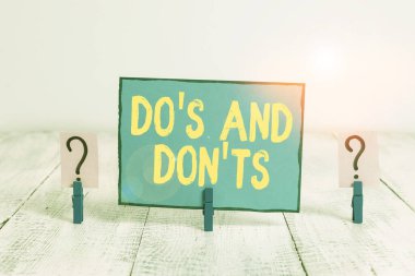 Mesaj işareti Do S ve Don 'u gösteriyor. Bazı faaliyet veya eylemlerle ilgili kavramsal fotoğraf kuralları veya gelenekler tahta masaya ataçlarla yazılmış ve parçalanmış kağıtlar.