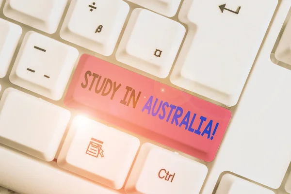 Konceptuell handskrift visar studie i Australien. Affärs fotoutställning gå in i utländsk land Beställ komplettera dina studier vit PC-tangentbord med anteckningspapper ovanför den vita bakgrunden. — Stockfoto