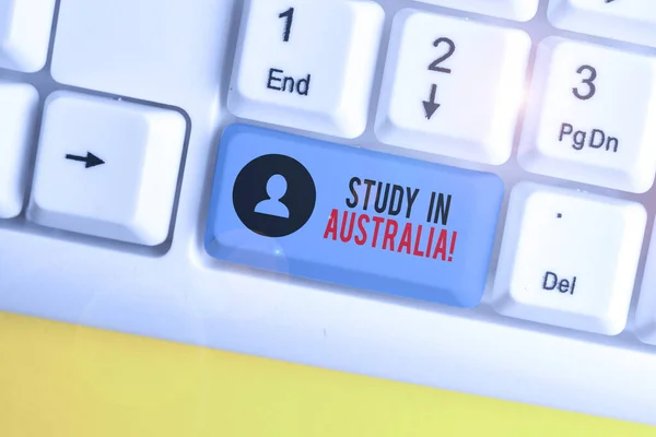 Woord schrijf tekst studie in Australië. Bedrijfsconcept om naar het buitenland te gaan bestel Voltooi uw studies wit PC-toetsenbord met lege notitie papier boven witte achtergrond sleutel kopiëren ruimte. — Stockfoto