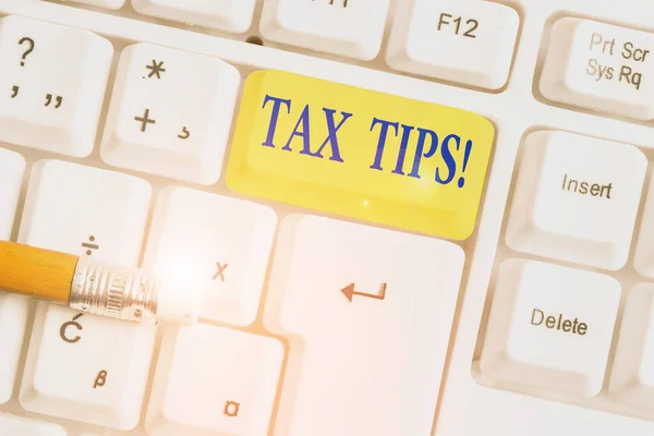 Writing note showing Tax Tips. Business photo showcasing compulsory contribution to state revenue levied by government White pc keyboard with note paper above the white background.