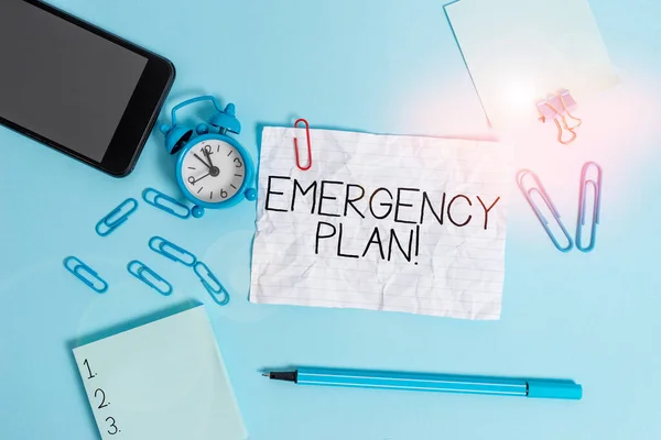 Handwriting text Emergency Plan. Concept meaning actions developed to mitigate damage of potential events Alarm clock clips notepad smartphone rubber band marker colored background.