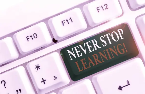 Texto de escrita de palavras Never Stop Learning. Conceito de negócio para continuar estudando ganhando novos conhecimentos ou materiais Teclado de PC branco com papel de nota vazio acima do espaço de cópia de chave de fundo branco . — Fotografia de Stock