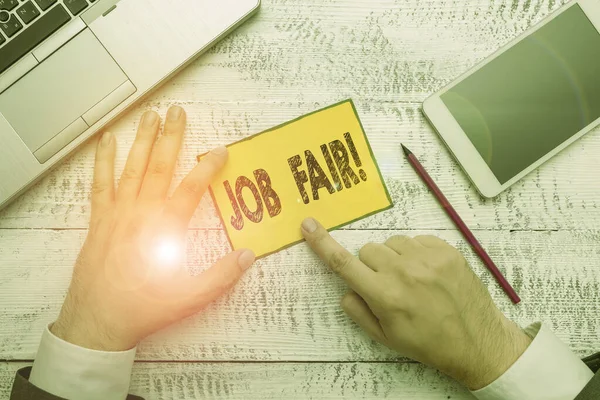 Texte manuscrit Job Fair. Concept signifiant événement dans lequel les employeurs recruteurs donnent des informations aux employés Papier à main près de l'équipement d'écriture et smartphone moderne . — Photo