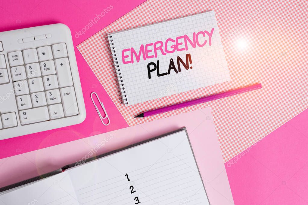 Writing note showing Emergency Plan. Business photo showcasing actions developed to mitigate damage of potential events Writing equipments and computer stuffs placed above colored plain table.
