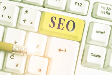 Seo 'yu gösteren bir not yazıyorum. İş fotoğrafı, beyaz arkaplanının üstündeki not kağıdıyla yakın iş yerinizi çevrimiçi olarak pazarlamanın inanılmaz etkili bir yolunu gösteriyor..