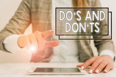 Writing note showing Do S And Don tS. Business photo showcasing Rules or customs concerning some activity or actions Business woman sitting with mobile phone on the table.