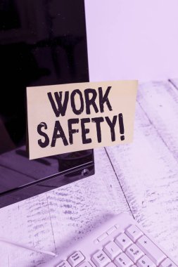 Kelime yazma, Çalışma Güvenliği. Çalışanların sağlığını sağlamak için uygulanan politika ve prosedürler için iş kavramı Beyaz klavyenin yanındaki siyah bilgisayar monitörü ekranına yapıştırılmış not kağıdı.