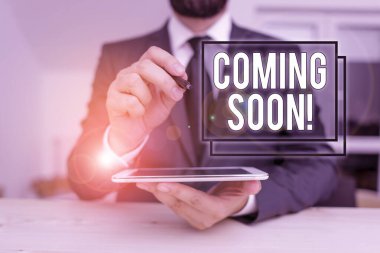 Conceptual hand writing showing Coming Soon. Business photo showcasing event or action that will happen after really short time Male human wear formal clothes present use hitech smartphone.