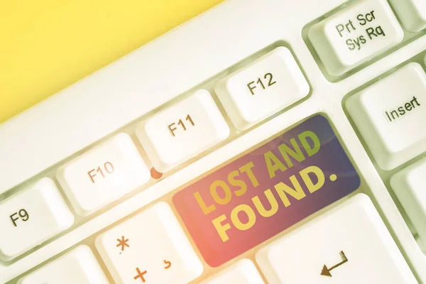 Signe texte montrant Lost And Found. Photo conceptuelle un endroit où les objets perdus sont stockés jusqu'à ce qu'ils récupèrent le clavier PC blanc avec du papier de note vide au-dessus de l'espace de copie de clé de fond blanc . — Photo