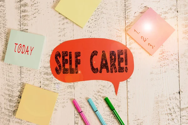 Text sign showing Self Care. Conceptual photo practice of taking action to preserve or improve ones own health Ballpoints pens blank colored speech bubble sticky notes wooden background. — Stock Photo, Image