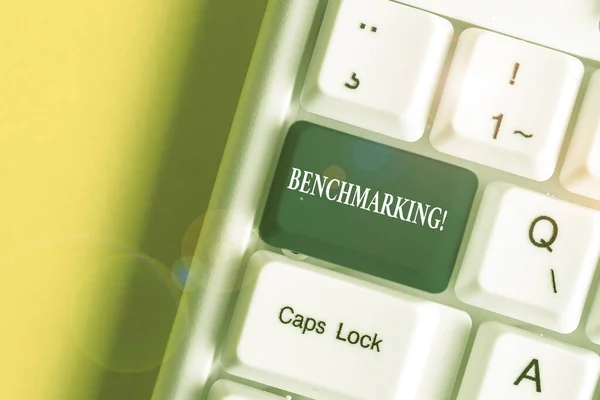 Texto manuscrito Benchmarking. Concepto que significa evaluar algo en comparación con el estándar o partituras Teclado de PC blanco con papel de nota vacío por encima del espacio de copia de la tecla de fondo blanco . — Foto de Stock