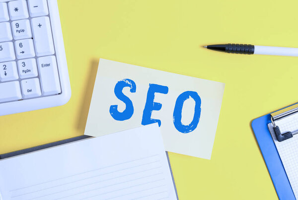Word writing text Seo. Business concept for incredibly effective way to market your near business online Empty orange paper with copy space on the yellow table.