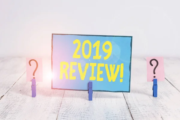 Text sign showing 2019 Review. Conceptual photo remembering past year events main actions or good shows Scribbled and crumbling sheet with paper clips placed on the wooden table.