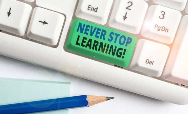 Escrevendo nota mostrando Nunca pare de aprender. Foto de negócios mostrando continuar estudando ganhando novos conhecimentos ou materiais Teclado pc branco com papel de nota acima do fundo branco . — Fotografia de Stock