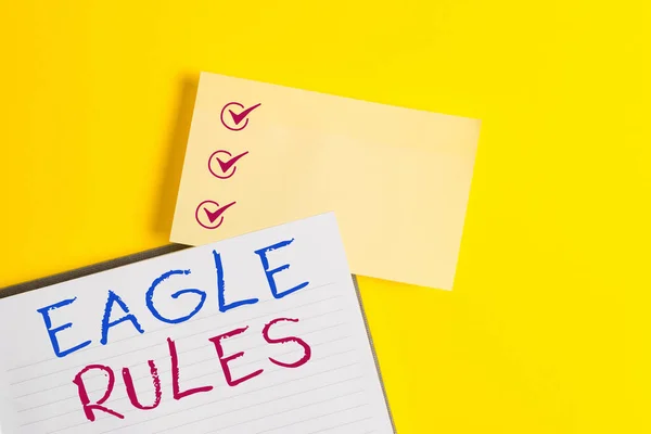 Conceptual hand writing showing Eagle Rules. Business photo text a huge set of design rules which your layout needs to pass Empty orange paper with copy space on the yellow table. — Stock Photo, Image