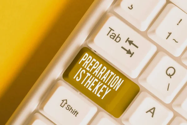 Handwriting text writing Preparation Is The Key. Concept meaning it reduces errors and shortens the activities White pc keyboard with empty note paper above white background key copy space.